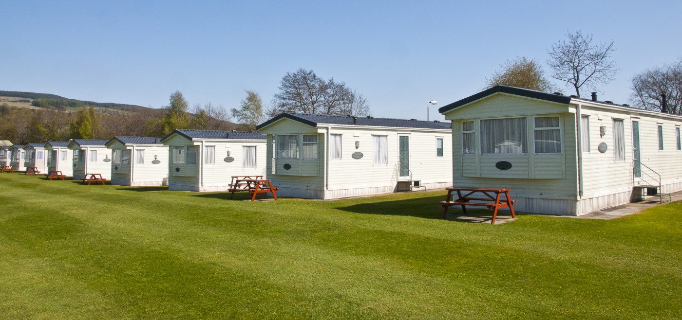 View of holiday homes at Fonab Caravan Park with large green space in the middle