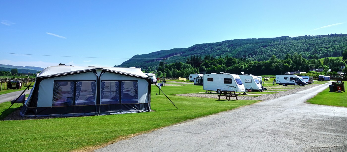 Tent next to road and touring caravans at Fonab