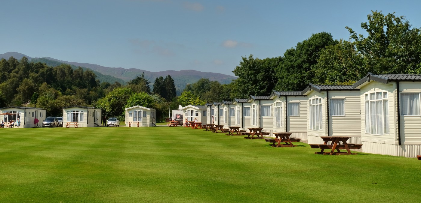 Large open grassy area in the middle of static caravans