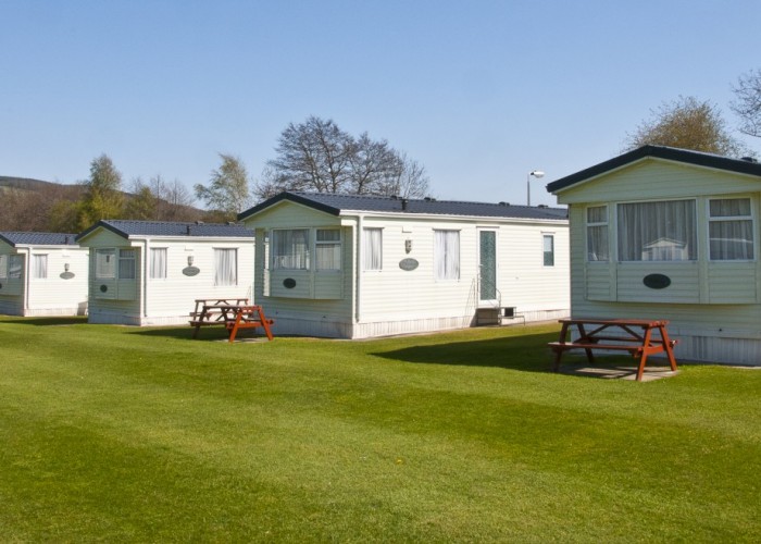 A layout of static caravans looking over the green grass area of Fonab Caravan Park.
